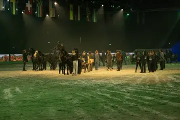 Vierspan en artiesten in de volle arena tijdens de show